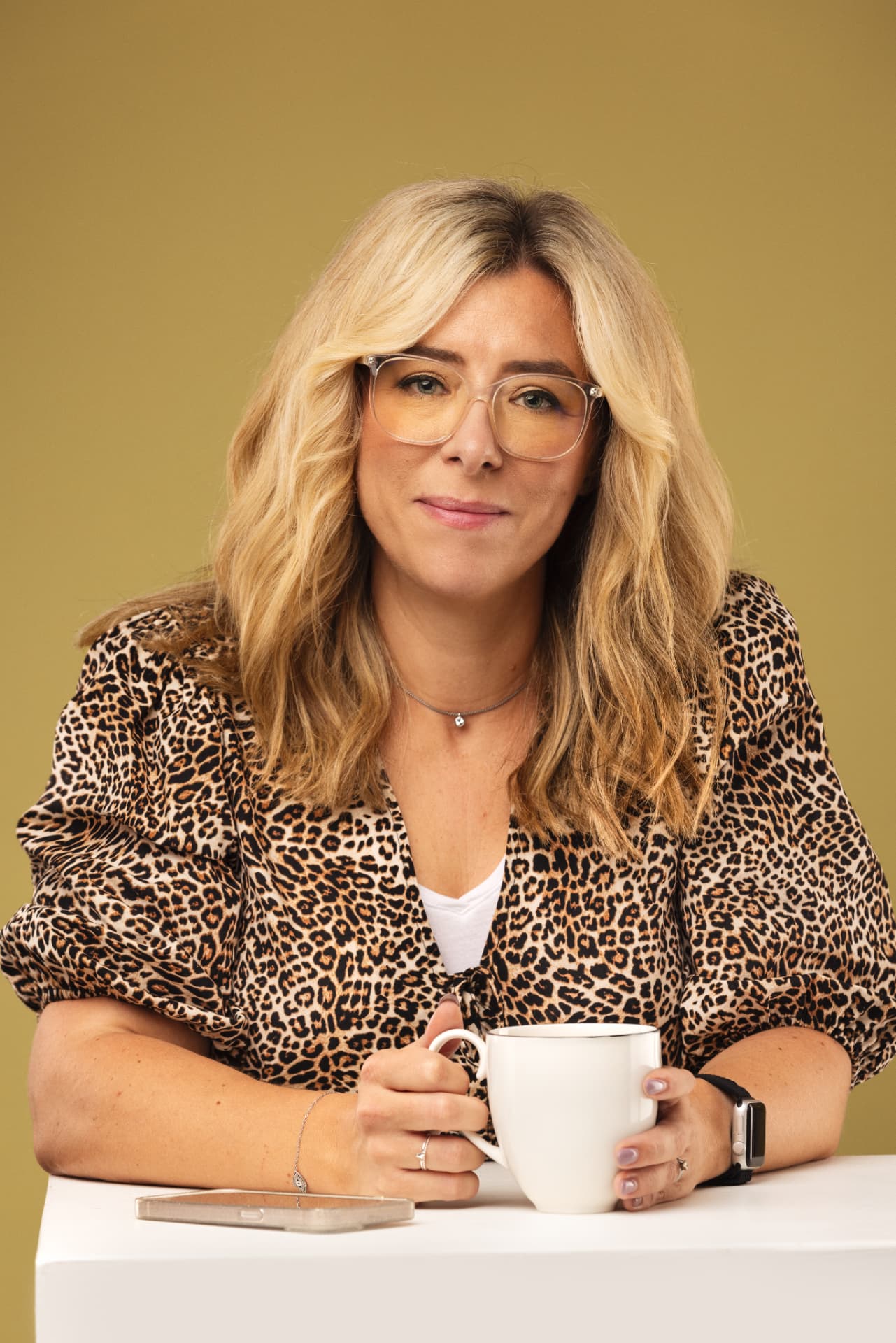 Lorna Moles sitting at a table with a mug